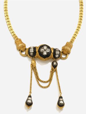 un collier en or avec des pierres noires et blanches montées sur une chaîne