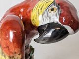 a figurine of a parrot sitting on top of a rock