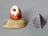 un œuf posé sur un rocher à côté d'une pyramide