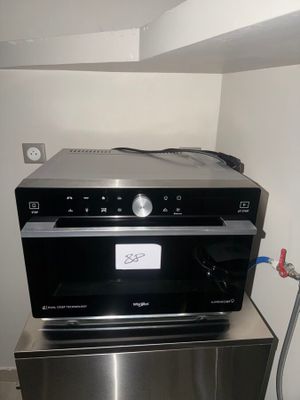 a silver microwave sitting on top of a stainless steel refrigerator