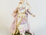 a figurine of a woman in a dress and hat