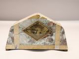 une horloge en marbre posée sur une table, avec un cadre doré