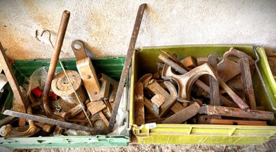 de nombreux outils dans une boîte verte posée par terre