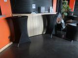 tables and stools in a room with orange walls and black flooring
