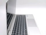a silver laptop with a black keyboard on a white surface