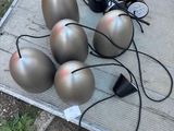 five silver balls sitting on a table with wires
