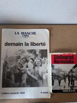 Deux livres sont posés sur une boîte, sur une table.