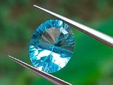 un gros plan d'un diamant bleu tenu par une pince