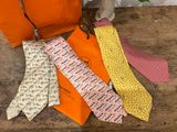 many ties laid out on a table next to a bag