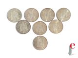 several coins are arranged in the shape of a heart on a white surface