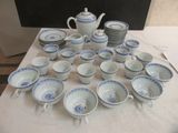 a lot of blue and white dishes and cups on a table