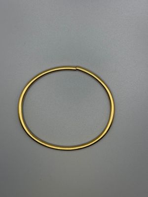 a close up of a gold bracelet on a gray surface
