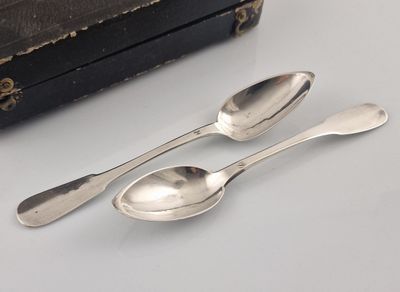 two spoons and two spoons sitting on a table