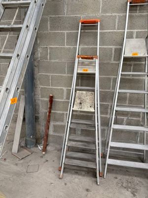 three ladders that are leaning against a wall