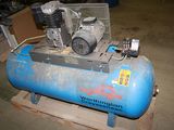 a blue air compressor sitting on top of a wooden pallet
