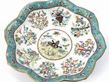 an image of a plate with a bird and flowers on it
