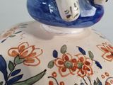 a white elephant sitting on top of a blue and white vase