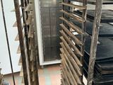 many trays of food on a rack in the kitchen