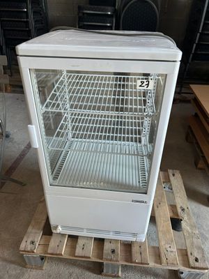 un réfrigérateur blanc posé sur une palette dans une pièce