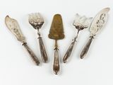 four silver spoons and a spatula on a white surface
