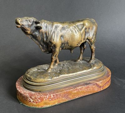 bronze statue of a bull on a marble base on a black background