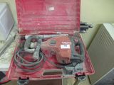 une boîte à outils rouge contenant une perceuse et un cordon