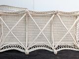 a white wicker baby crib that is on a black surface