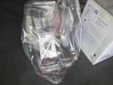 un sac en plastique posé par terre à côté d'une boîte