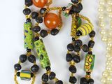 two necklaces with beads and beads on a white surface