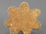 a gold plate with a flower shaped design on it