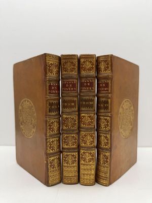 trois livres sont empilés sur une surface blanche