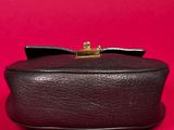 a black box with a bow on top of it on a red background