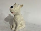 a small white dog figurine sitting on a white surface