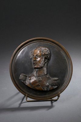 plaque en bronze représentant le buste d'un homme, posée sur un socle