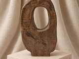 un petit vase posé sur un socle blanc