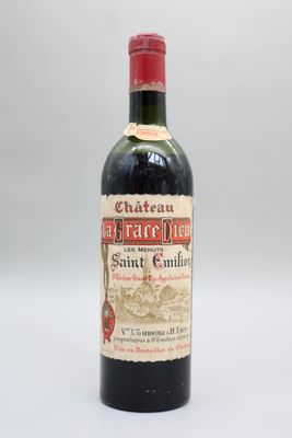 une bouteille de vin rouge posée sur une table blanche