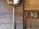 a lot of silver spoons and spoons in a box