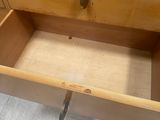 a wooden drawer with a metal handle in a bathroom