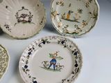 four plates with different designs on them sitting on a table