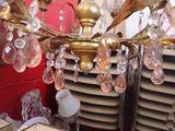 a gold chandelier with pink crystals hanging from it