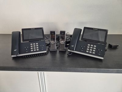 trois téléphones posés sur une table, avec un autre téléphone posé dessus