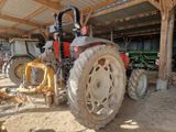 un tracteur garé sur un terrain en terre battue