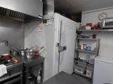 une cuisine équipée d'une cuisinière, d'un évier, d'un réfrigérateur et d'autres appareils électroménagers