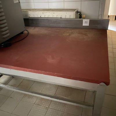 un plan de travail rouge dans une cuisine, sur lequel est posé un micro-ondes