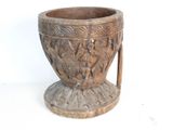 a wooden vase with carvings on it on a white surface