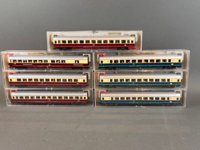 Plusieurs trains miniatures sont empilés les uns sur les autres sur une table