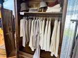 an image of a closet with clothes on hangers