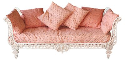 un canapé rose recouvert de nombreux coussins