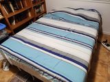 un lit qui se trouve dans une chambre équipée d'une bibliothèque