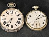 deux vieilles montres de poche posées l'une à côté de l'autre sur une table